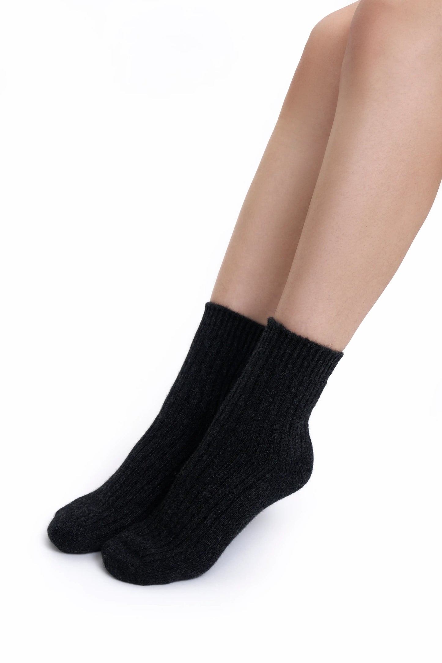A close-up of premium charcoal Mongolian cashmere socks worn by a female Mongolian model, highlighting their fine knit and elegant design.