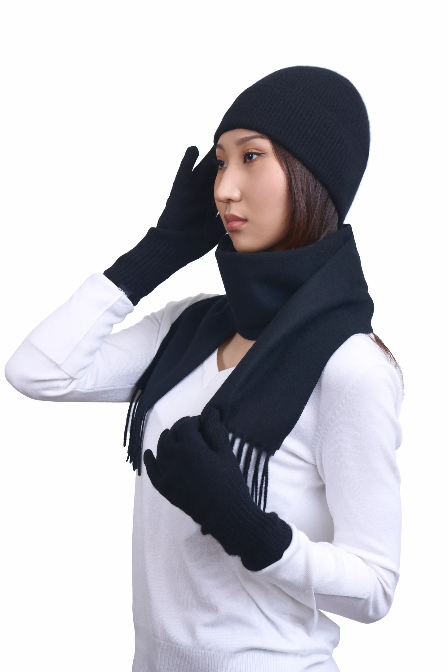 Soft and warm Mongolian cashmere gloves, scarf and beanie in black, worn by a female Mongolian model wearing a white sweater