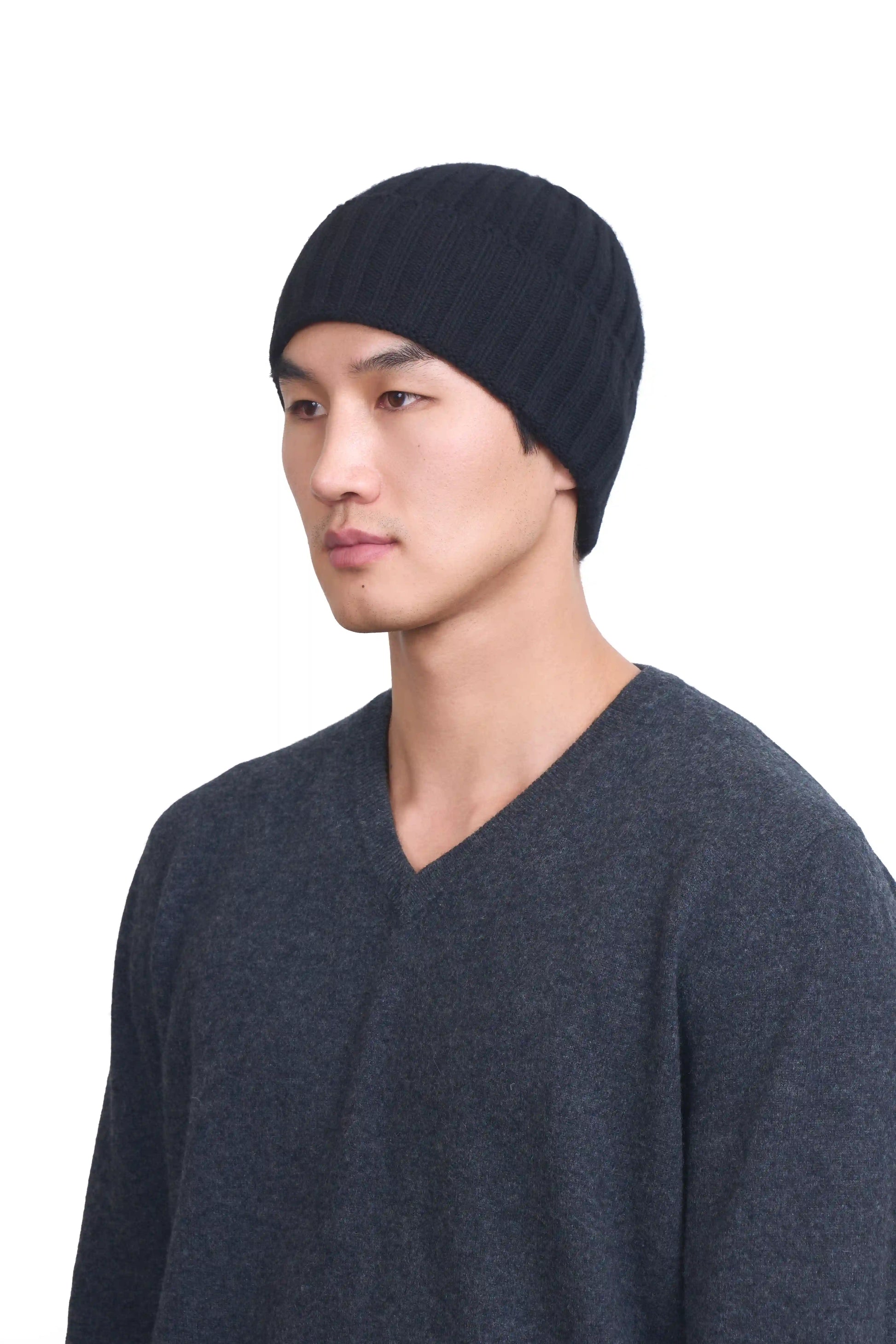 Mongolian male model in 3/4 view wearing a soft black cashmere beanie, highlighting the luxurious texture and elegant design against a neutral background