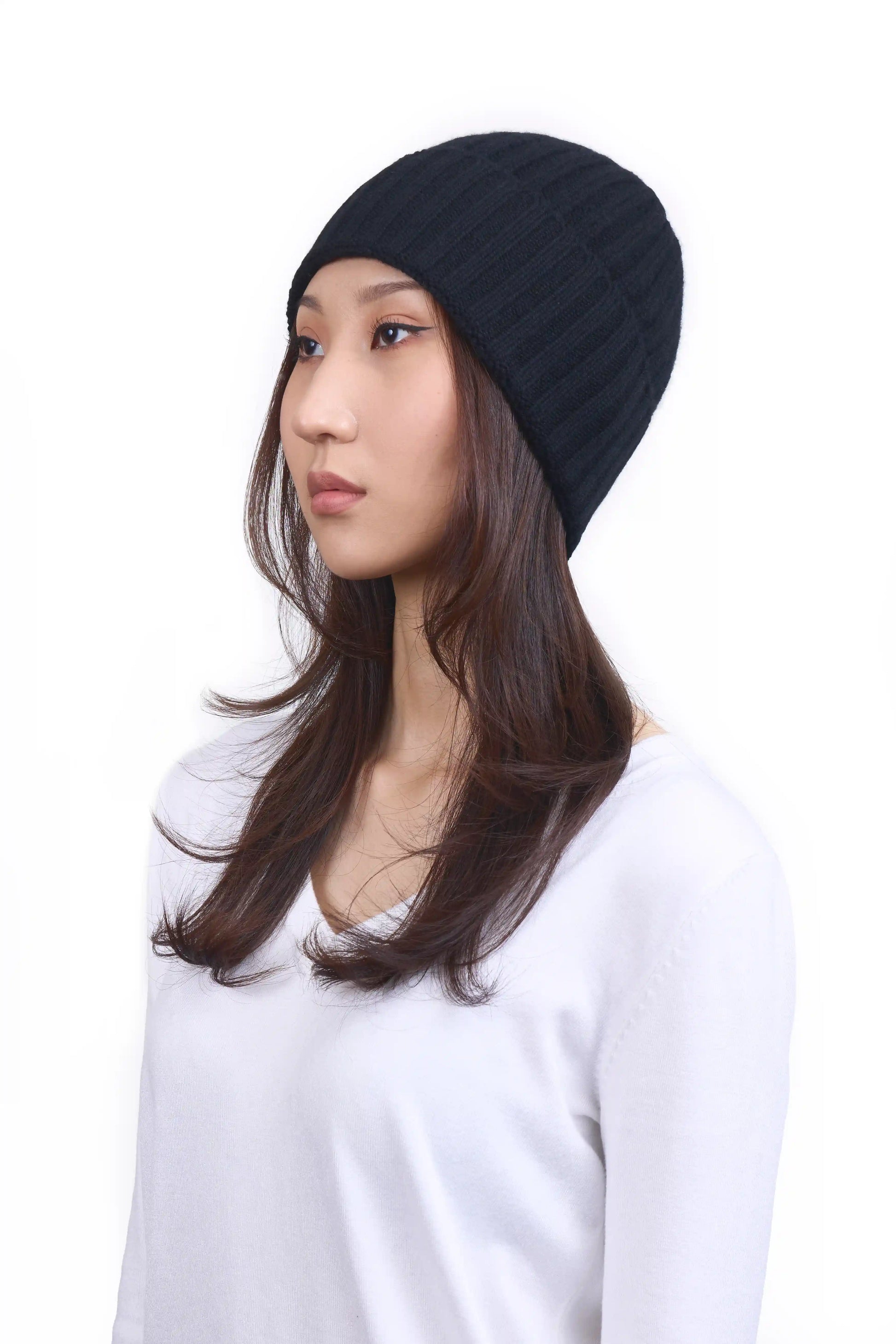 Mongolian female model in 3/4 view wearing a warm black cashmere beanie, highlighting the luxurious texture and elegant design against a neutral background