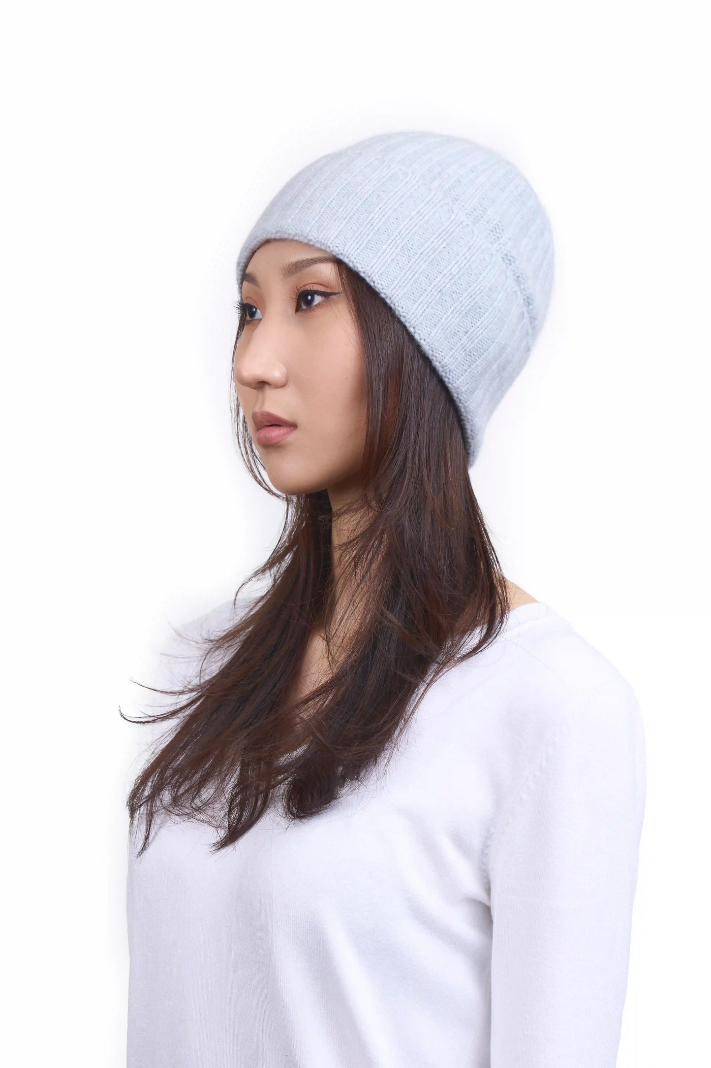 Mongolian female model in 3/4 view wearing a soft light gray cashmere beanie, highlighting the luxurious texture and elegant design against a neutral background