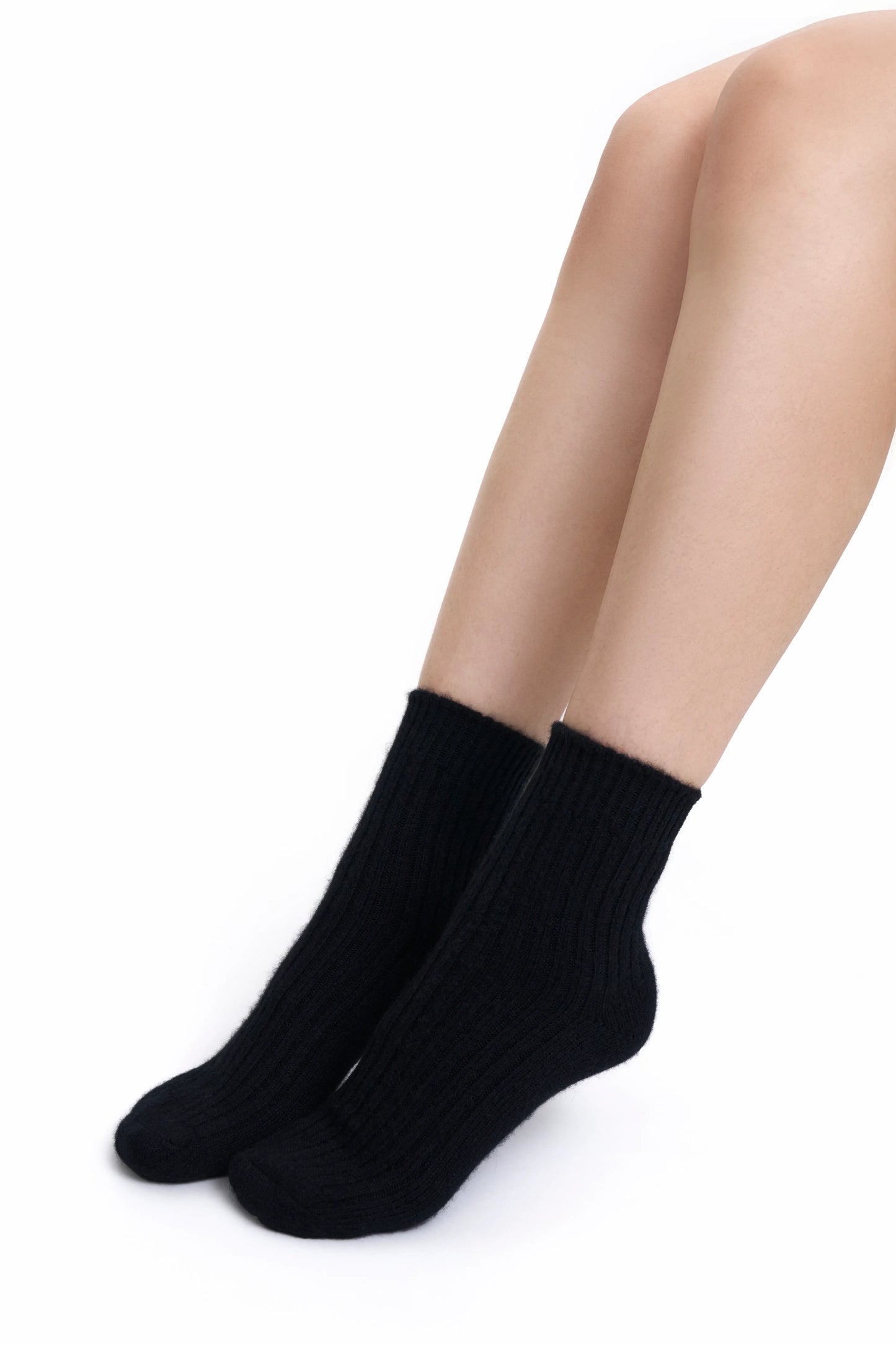 A close-up of premium black Mongolian cashmere socks worn by a female Mongolian model, highlighting their fine knit and elegant design.