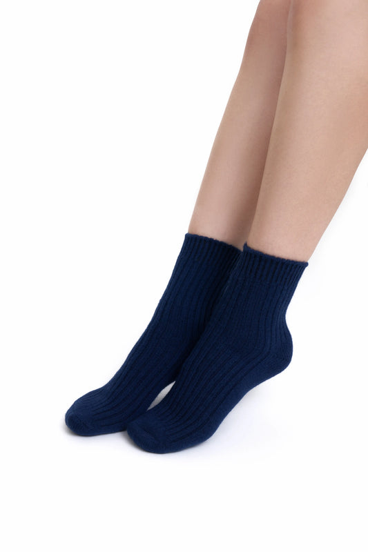 A close-up of premium navy blue Mongolian cashmere socks worn by a female Mongolian model, highlighting their fine knit and elegant design.