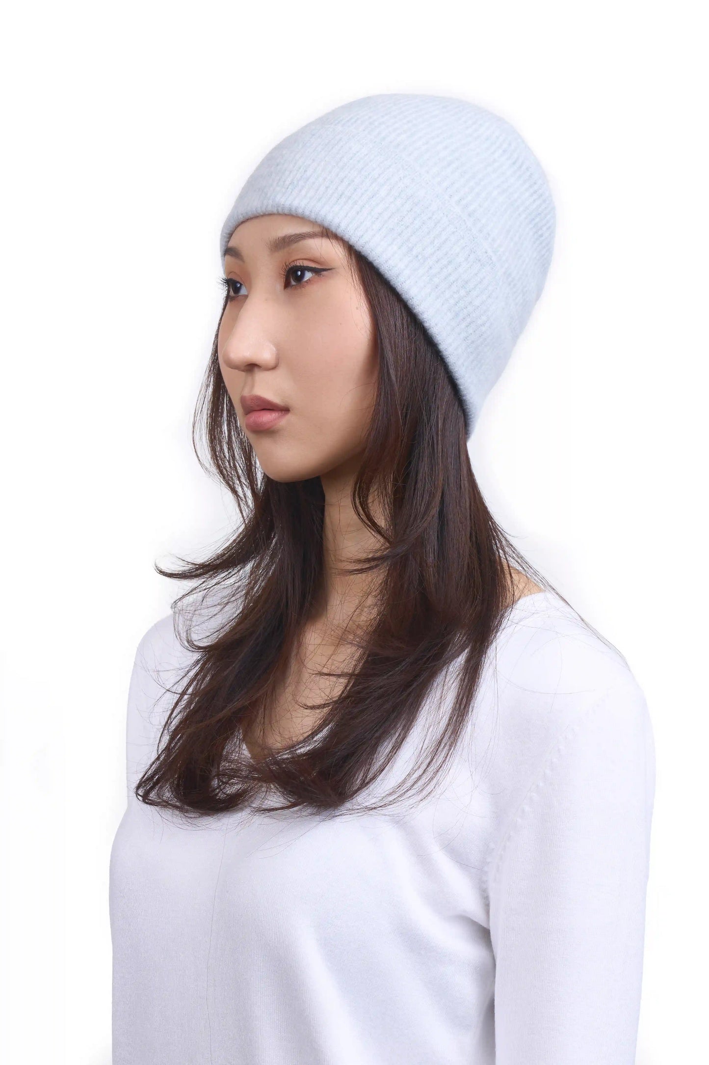 Mongolian female model in 3/4 view wearing a warm light gray cashmere beanie, highlighting the luxurious texture and elegant design against a neutral background
