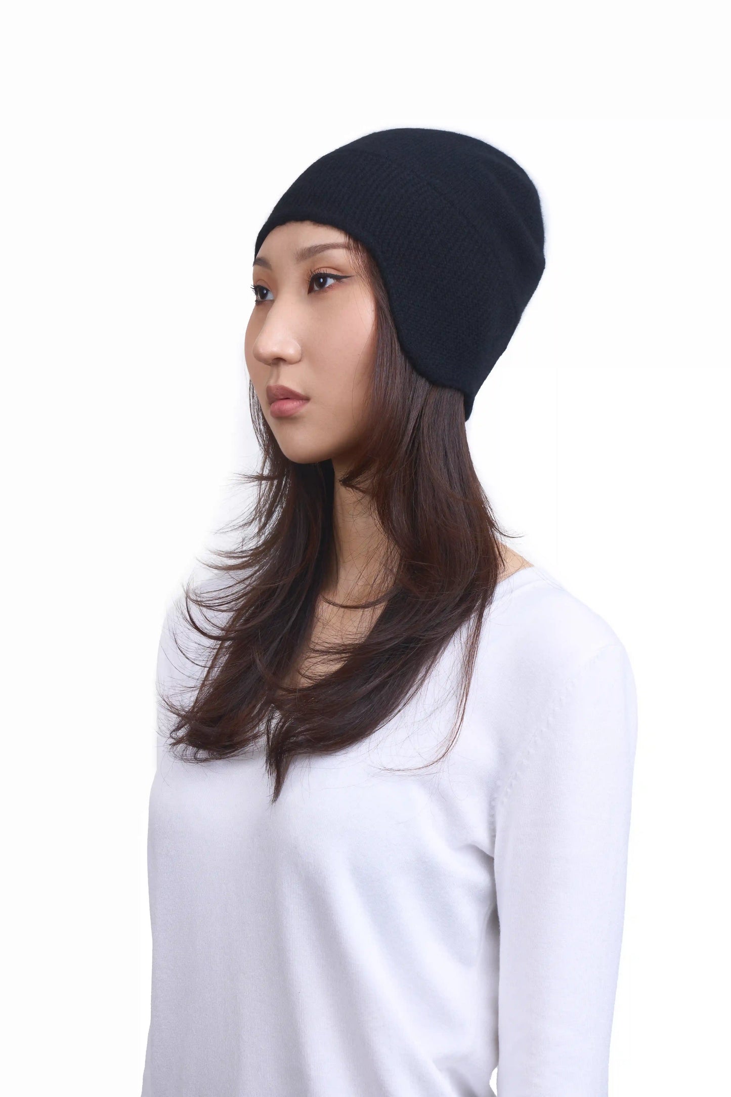 Mongolian female model in 3/4 view wearing a soft black cashmere beanie, highlighting the luxurious texture and elegant design against a neutral background